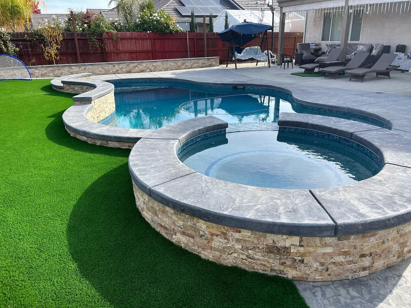 Custom pool and spa with stone surround built by a California custom pool builder