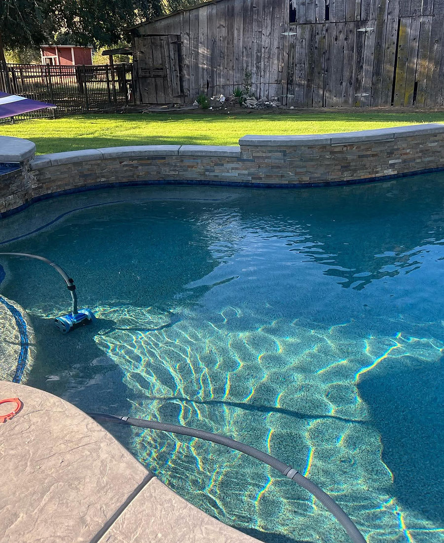 Natural travertine stone coping surrounding a swimming pool in California